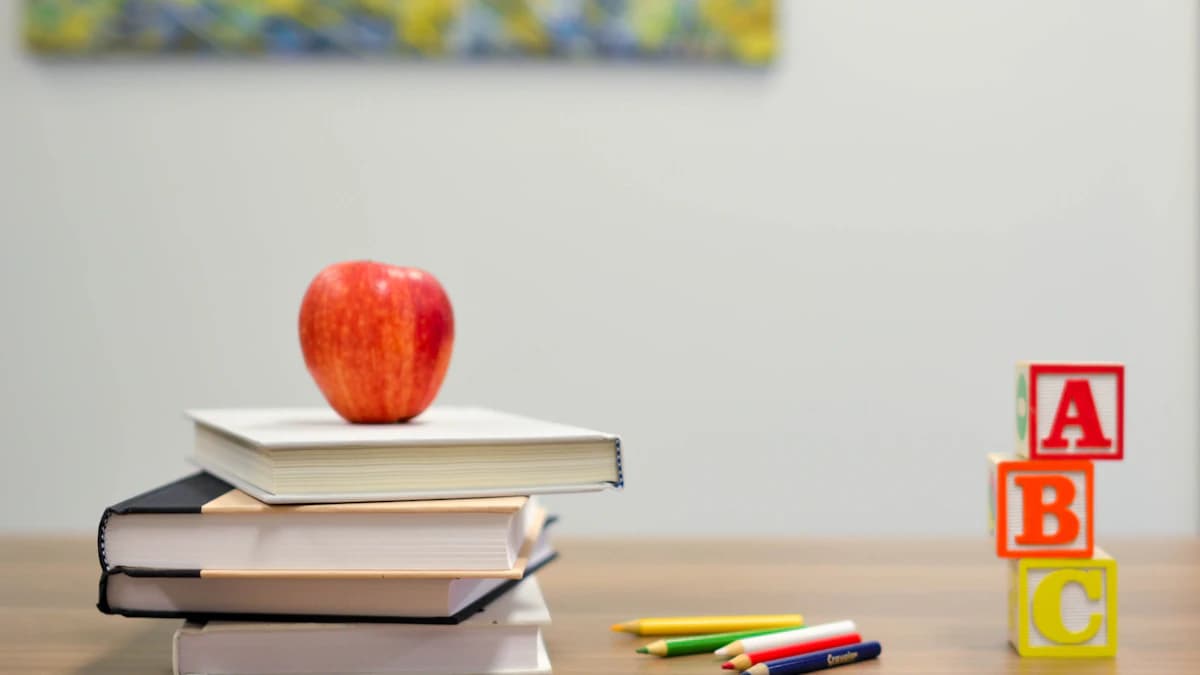 Books, apple and ABC blocks on a school desk